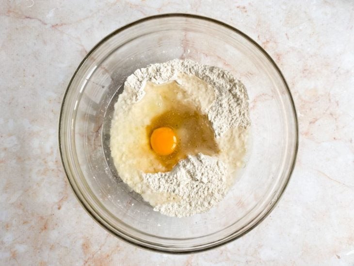 Ovo, sal, açúcar, óleo e água adicionados ao recipiente.