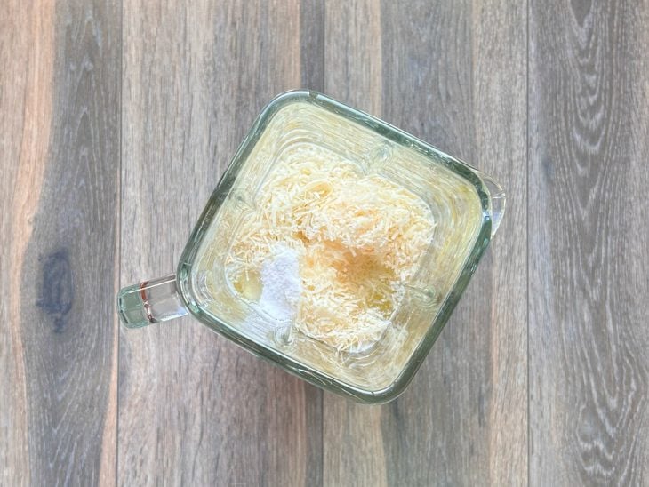 Ovos, óleo, leite, sal e queijo parmesão misturados em um liquidificador.