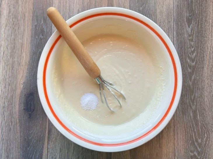 Mistura do liquidificador em uma tigela com farinha e sal.