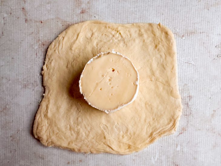 Massa aberta com uma das metades do queijo.