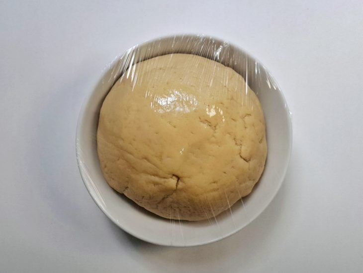 Massa em outro recipiente coberto por plástico filme.