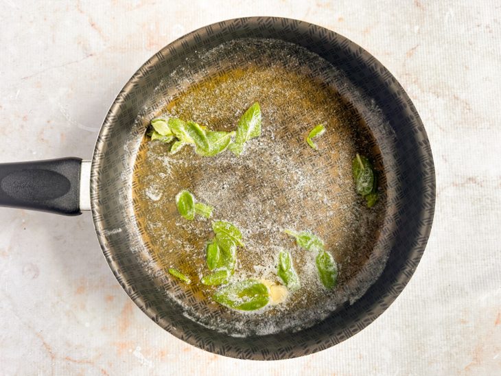 Na panela, manteiga derretida com as folhas de sálvia.