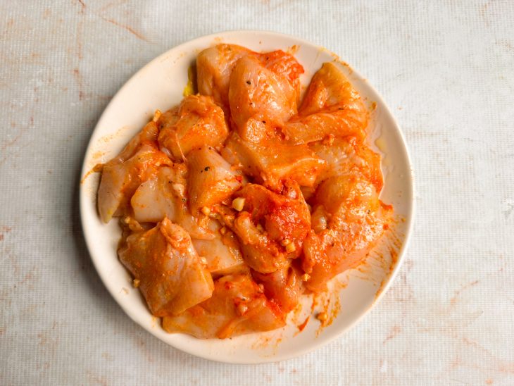 Frango temperado com alho, páprica, mostarda, sal e azeite.