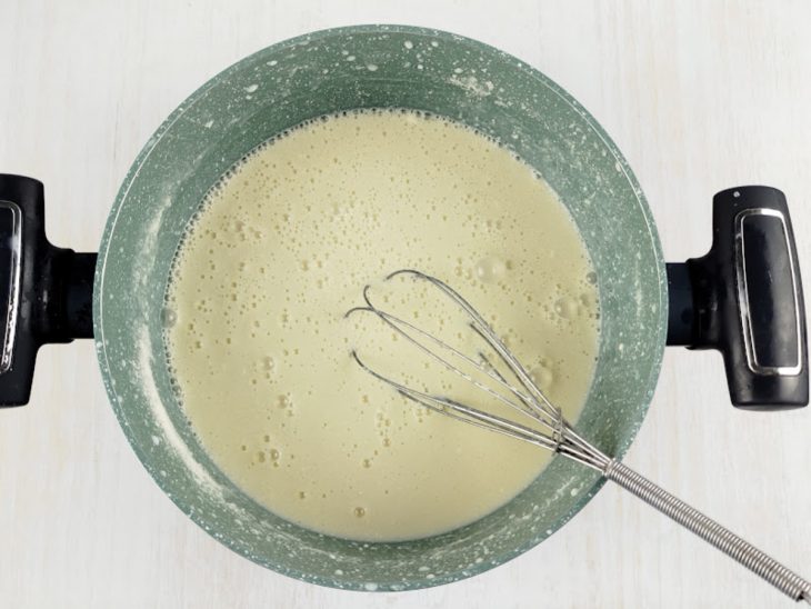 Leite em pó e a gema agregados na mistura da panela.