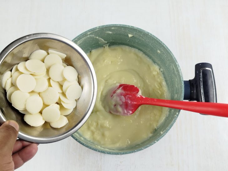 Chocolate branco sendo adicionado na panela.