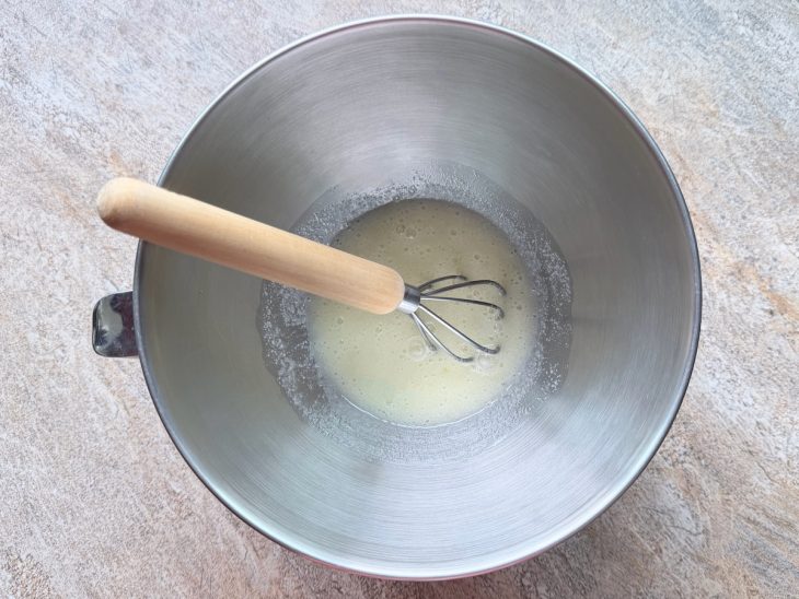 Claras e açúcar sendo misturados em uma tigela.