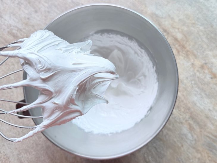 Creme sendo batido na batedeira até formar picos firmes.