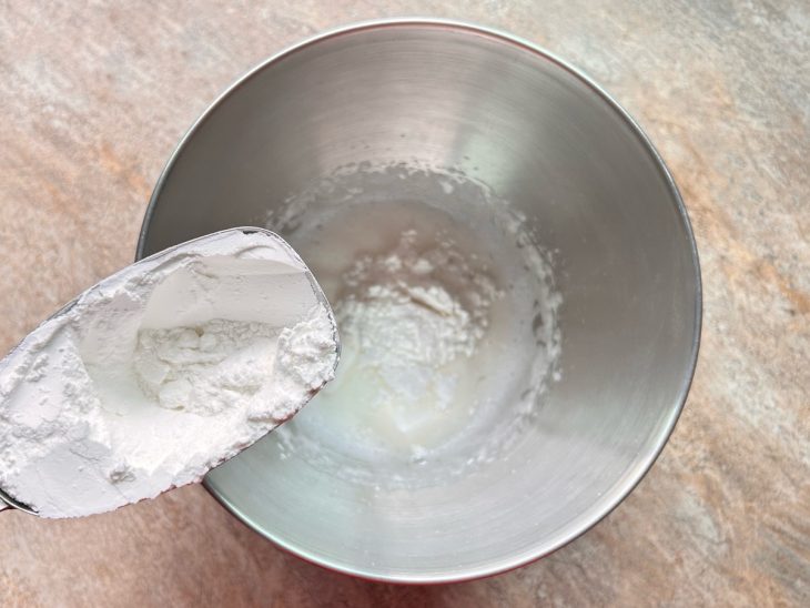 Na tigela, açúcar de confeiteiro sendo adicionado.