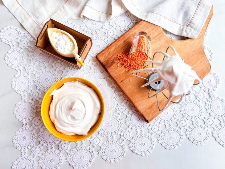 Merengue pronto, servido em tigela, batedor ao lado mostrando o ponto.