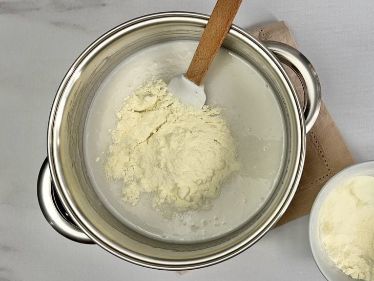 Uma panela com arroz, água, açúcar e leite em pó.