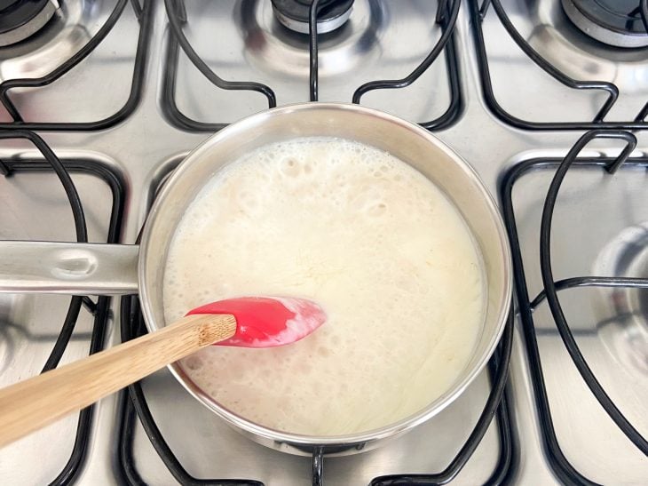 Panela no fogão com os ingredientes do mingau cozinhando.