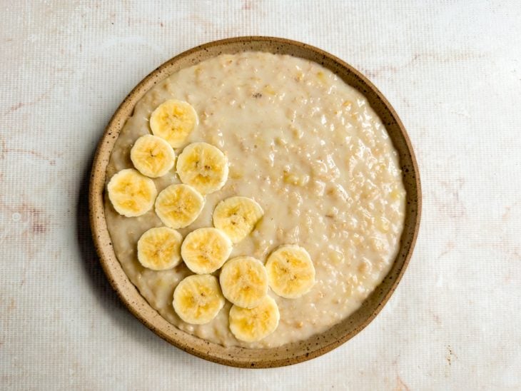 Rodelas de banana adicionadas por cima do mingau.