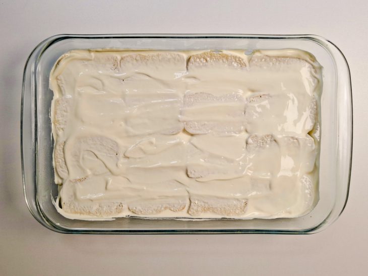 Pães montados lado a lado na travessa, formando uma camada uniforme.