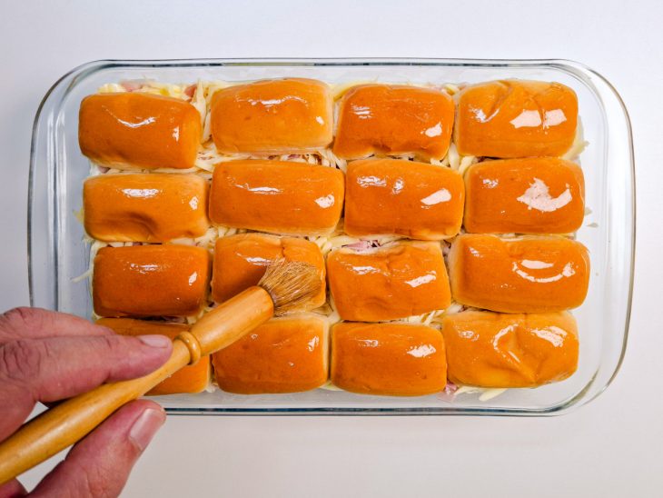 Tampas das bisnaguinhas sendo posicionadas sobre cada base.