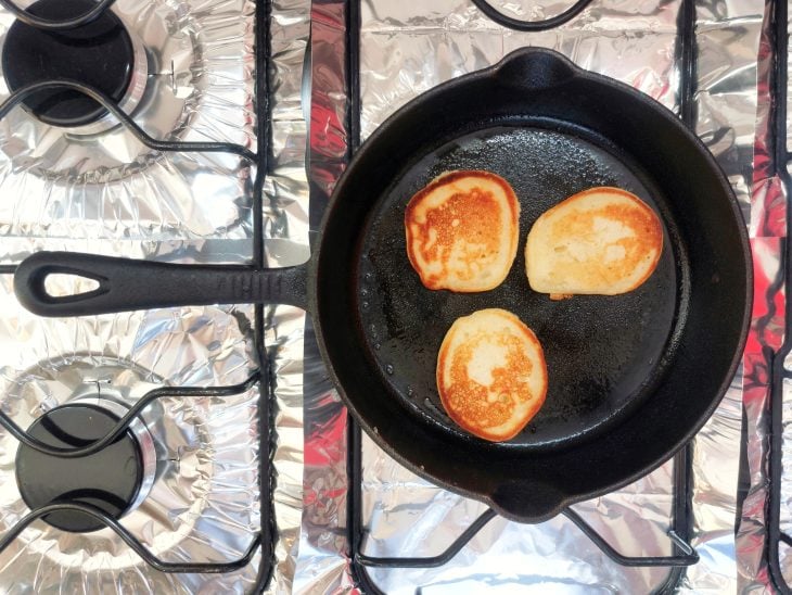 Mini panquecas viradas para serem douradas do outro lado.