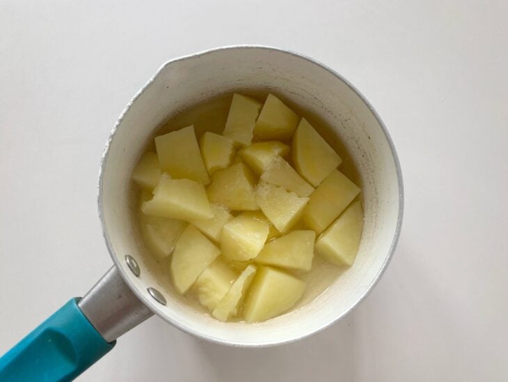 Batata cortada e cozida na panela.