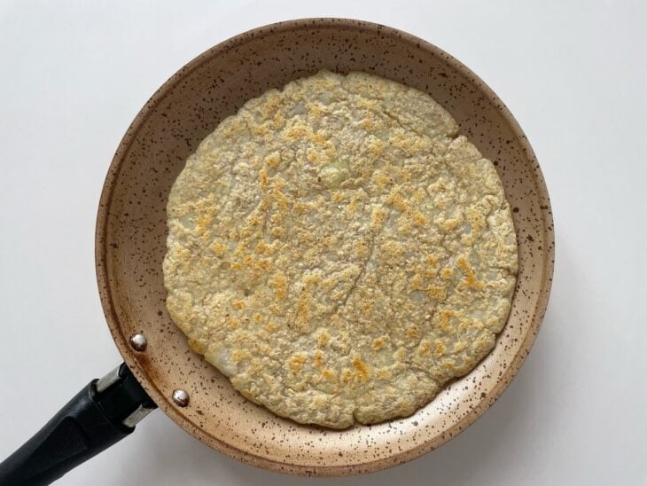 Disco de massa dourado e virado na frigideira.