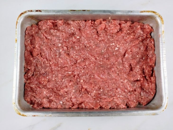 Uma forma com a carne temperada.