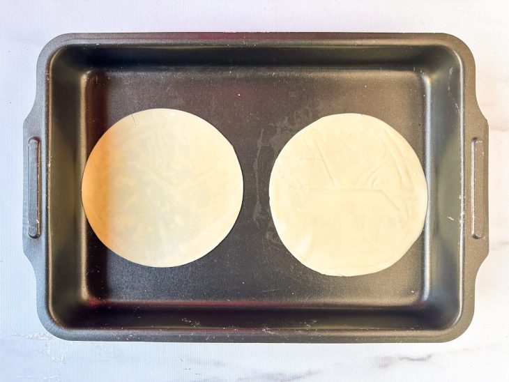 Numa assadeira, as massas de pastel.