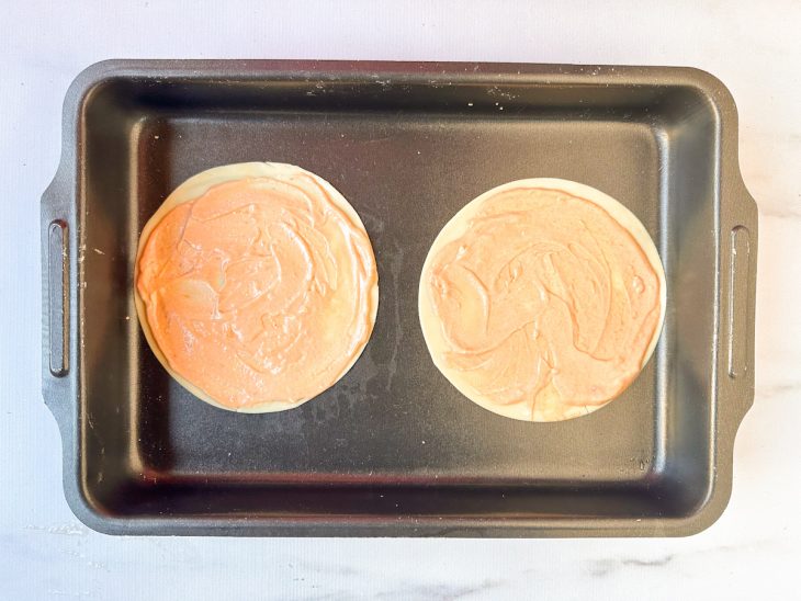 Na assadeira, o molho de tomate sobre as massas.