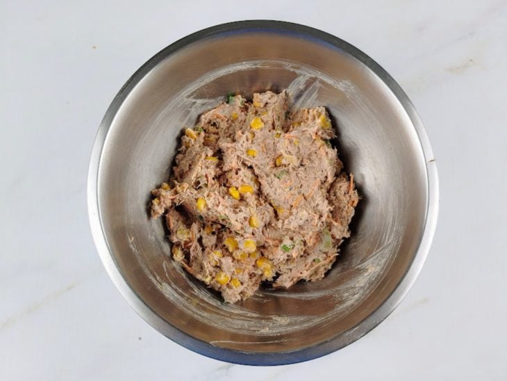 Uma tigela com creme de ricota, atum, milho, cenoura e temperos.