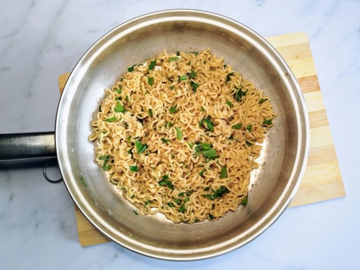 Uma panela com miojo cozido e cheiro-verde.