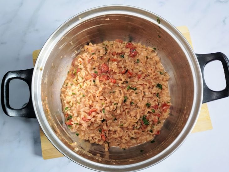 Uma panela com a mistura do miojo com o molho de tomate.
