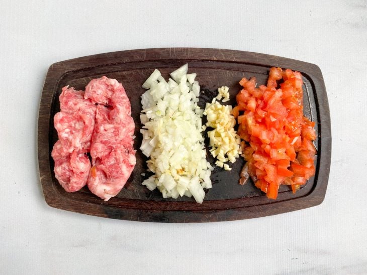Uma tábua contendo ingredientes picados.