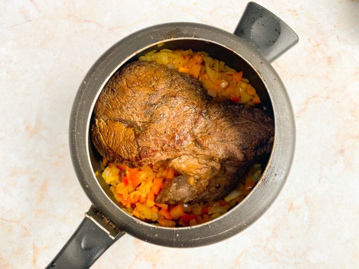 Panela com a carne, alho, tomate, cebola e temperos.