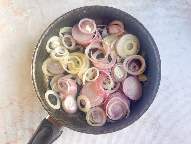 Cebolas sendo refogadas na panela com azeite.