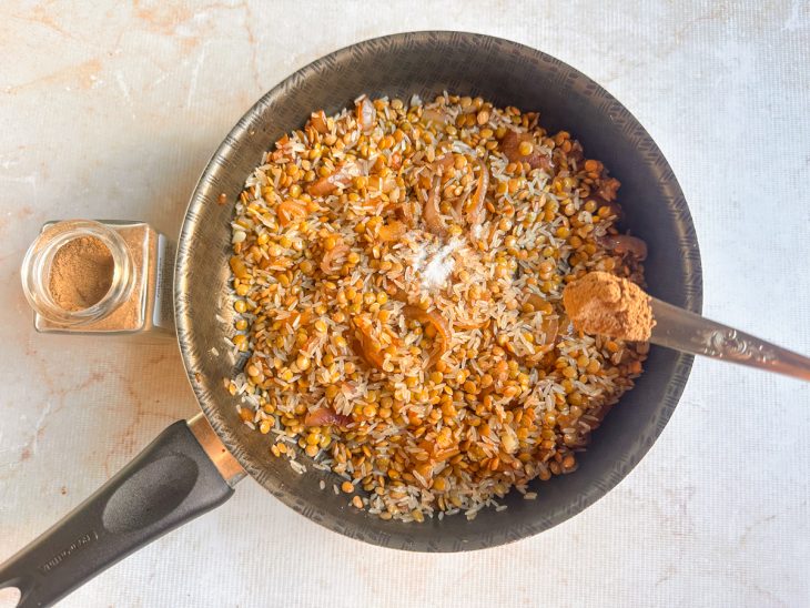 Temperos sendo adicionados e misturados aos grãos.