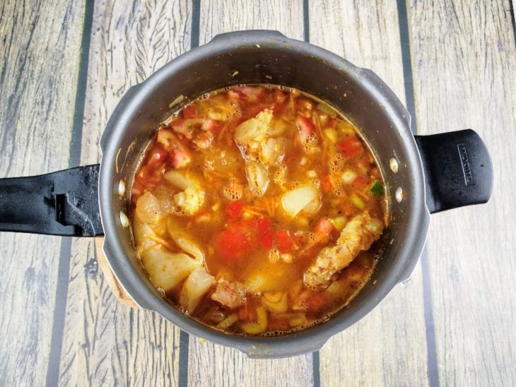 Cenoura, tomate e pimentões verde, vermelho e amarelo adicionados a panela de pressão.