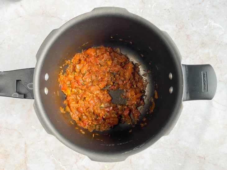 Extrato de tomate e cheiro-verde adicionados na panela.