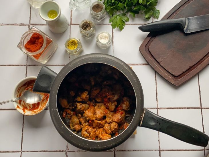 Uma panela de pressão contendo as moelas seladas e legumes refogados.