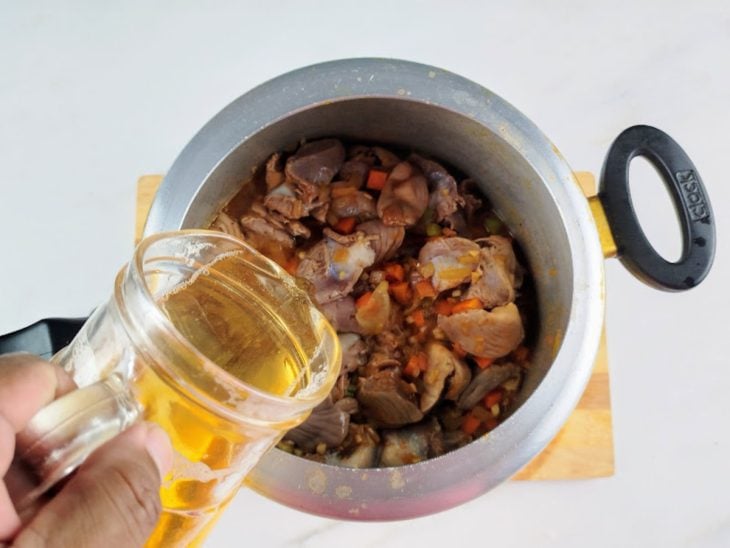 Cerveja sendo despejada na panela de pressão com os outros ingredientes.
