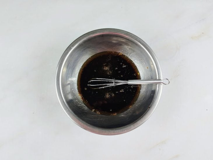Shoyu, vinagre e azeite misturados em um recipiente de alumínio.