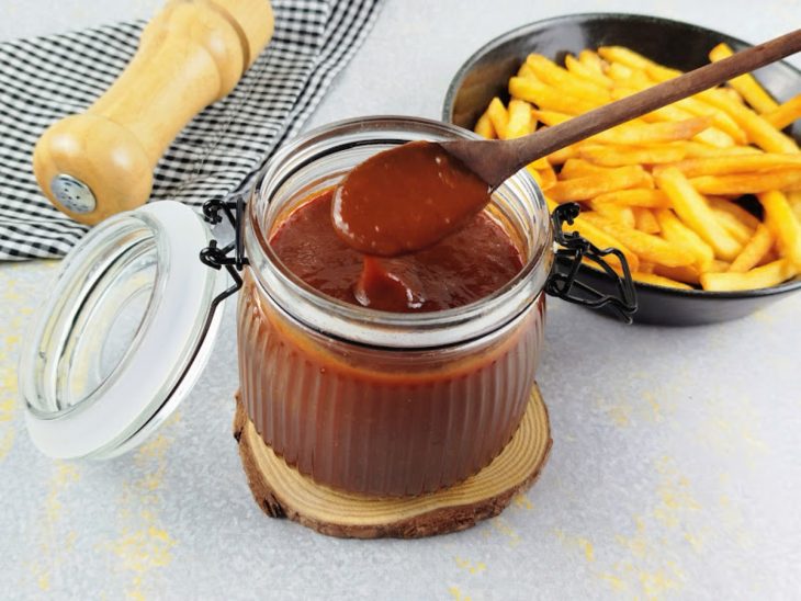 Molho barbecue caseiro em um potinho com colher.