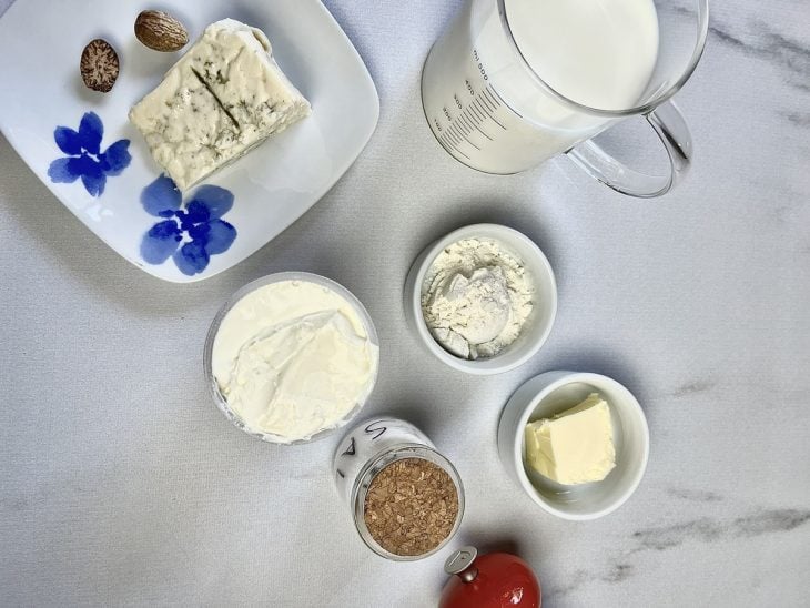 Ingredientes para o molho bechamel com queijo reunidos em uma bancada.