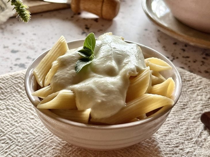 Molho bechamel com queijo servido com macarrão tipo penne.