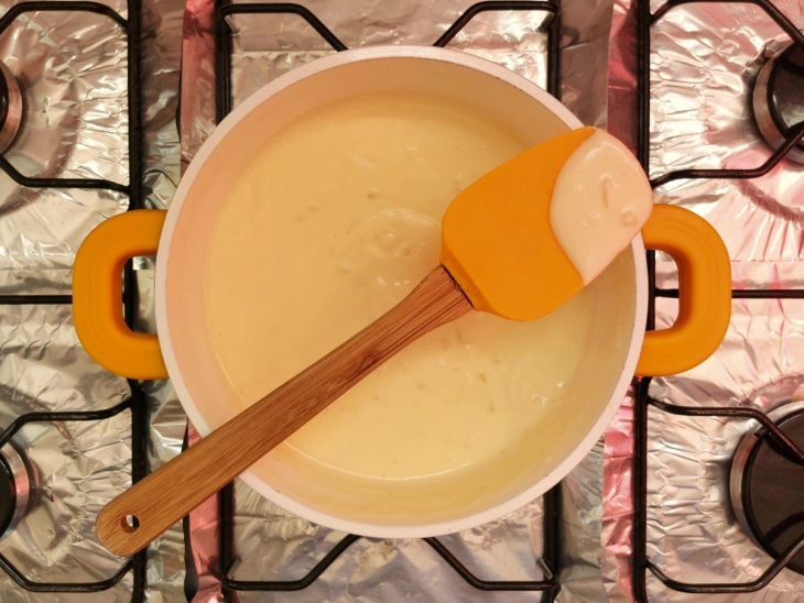 Uma panela contendo molho branco com creme de leite.