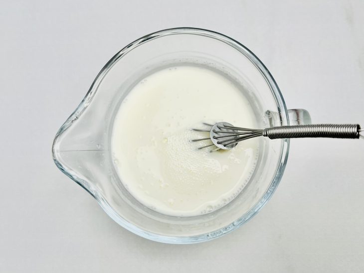 Água e creme de leite incorporados num recipiente.