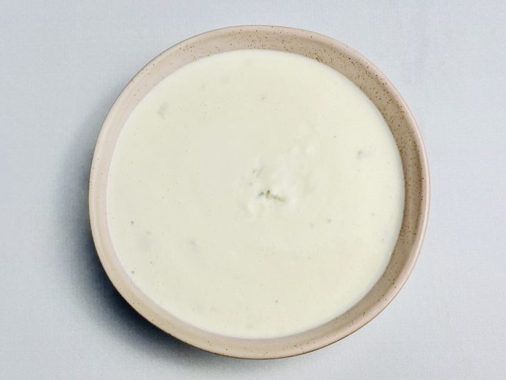 Molho branco despejado num recipiente.