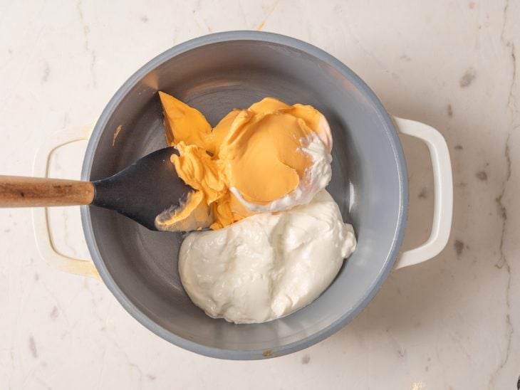Uma panela com o cheddar e o creme de leite.
