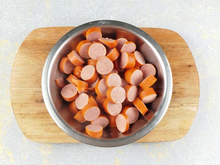 Rodelas de salsicha em um recipiente redondo de inox.
