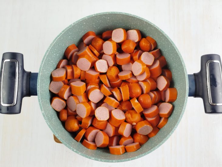 Na panela, as salsichas cortadas em rodelas.