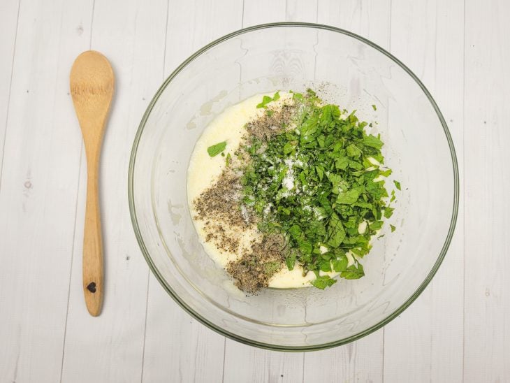 Uma tigela com azeite, suco de limão, iogurte natural, hortelã, sal e pimenta-do-reino.