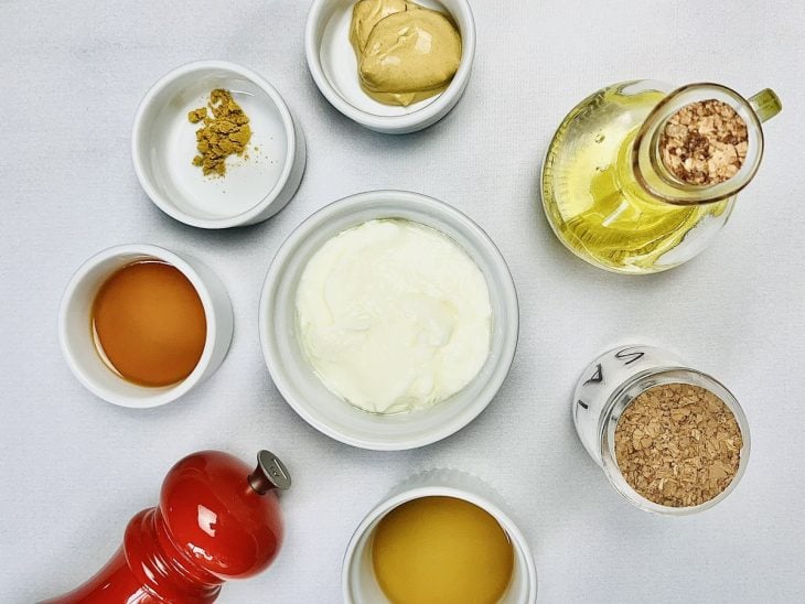 Ingredientes para preparar a receita de molho de iogurte com mostarda dijon reunidos.