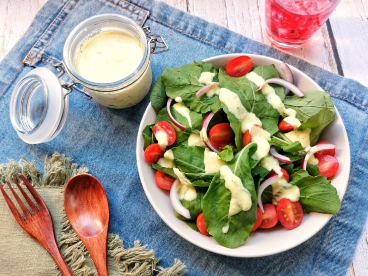 Molho de iogurte finalizado e servido por cima da salada.