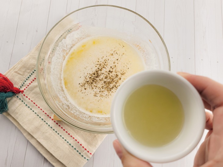 Temperos e suco de limão sendo adicionados à manteiga derretida.