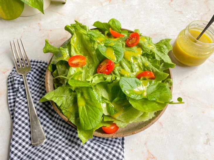 Prato de salada com molho servido na superfície.